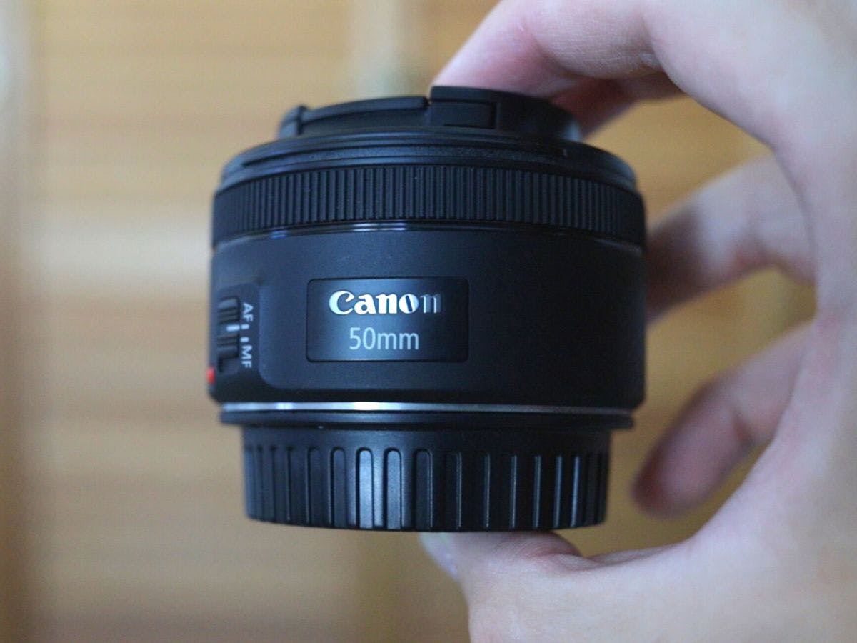 Holding the Canon EF 50mm f/1.8.