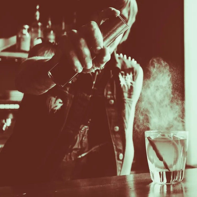 Man spraying a cocktail drink.