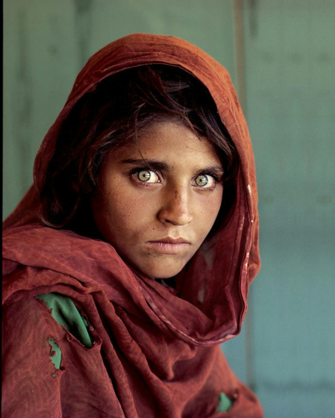 Girl with green eyes with a red scarf.