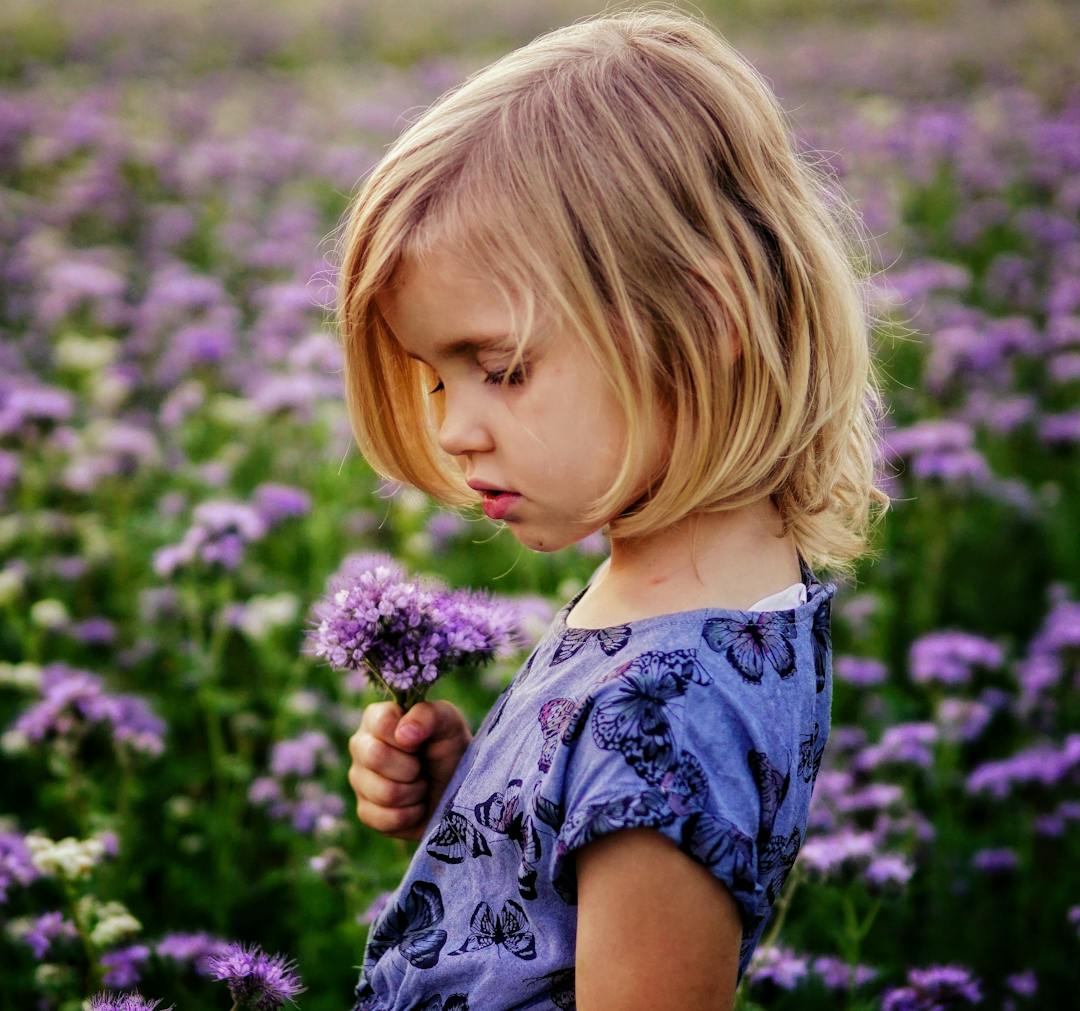 Little girl playing in flower field.
