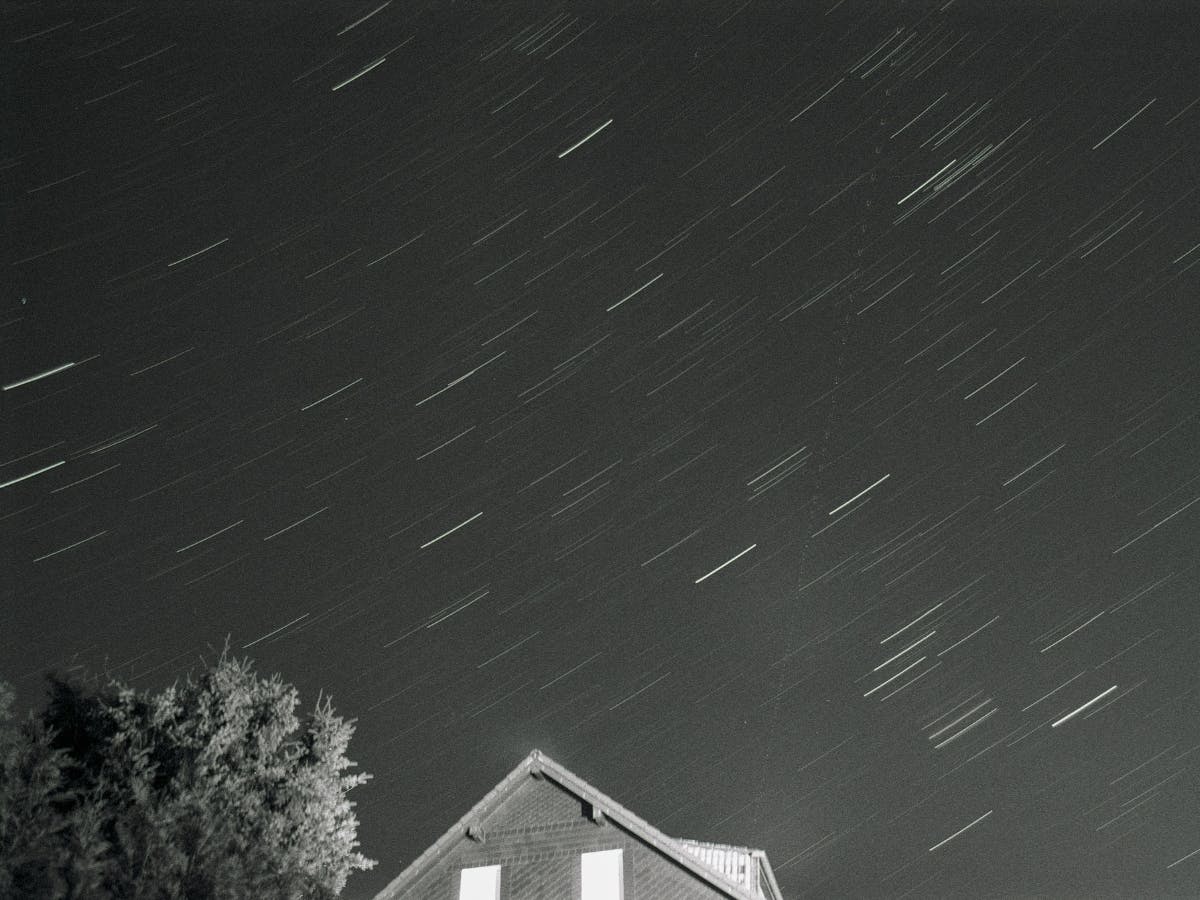 Stars in night sky by house.