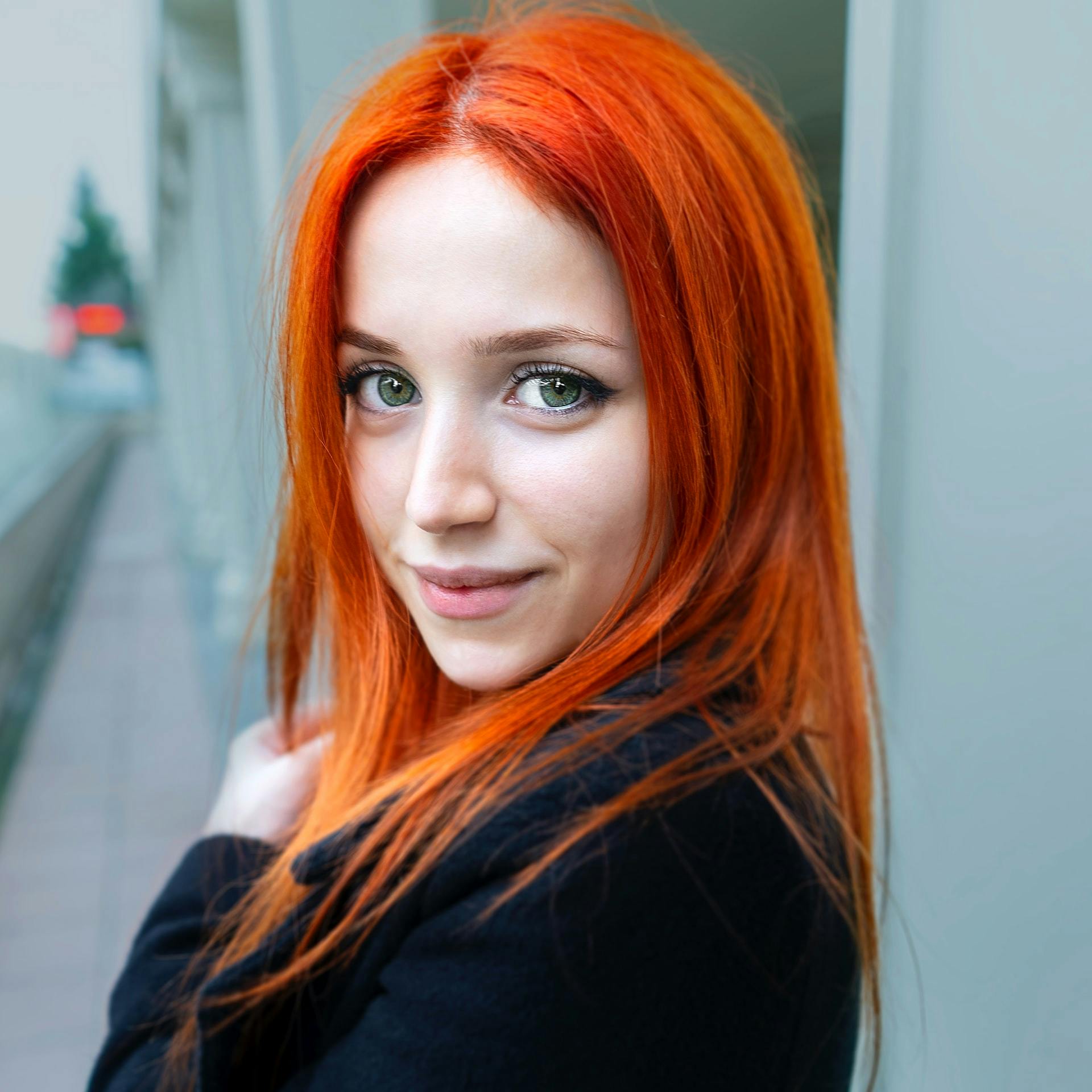 Woman with orange hair looking at camera.