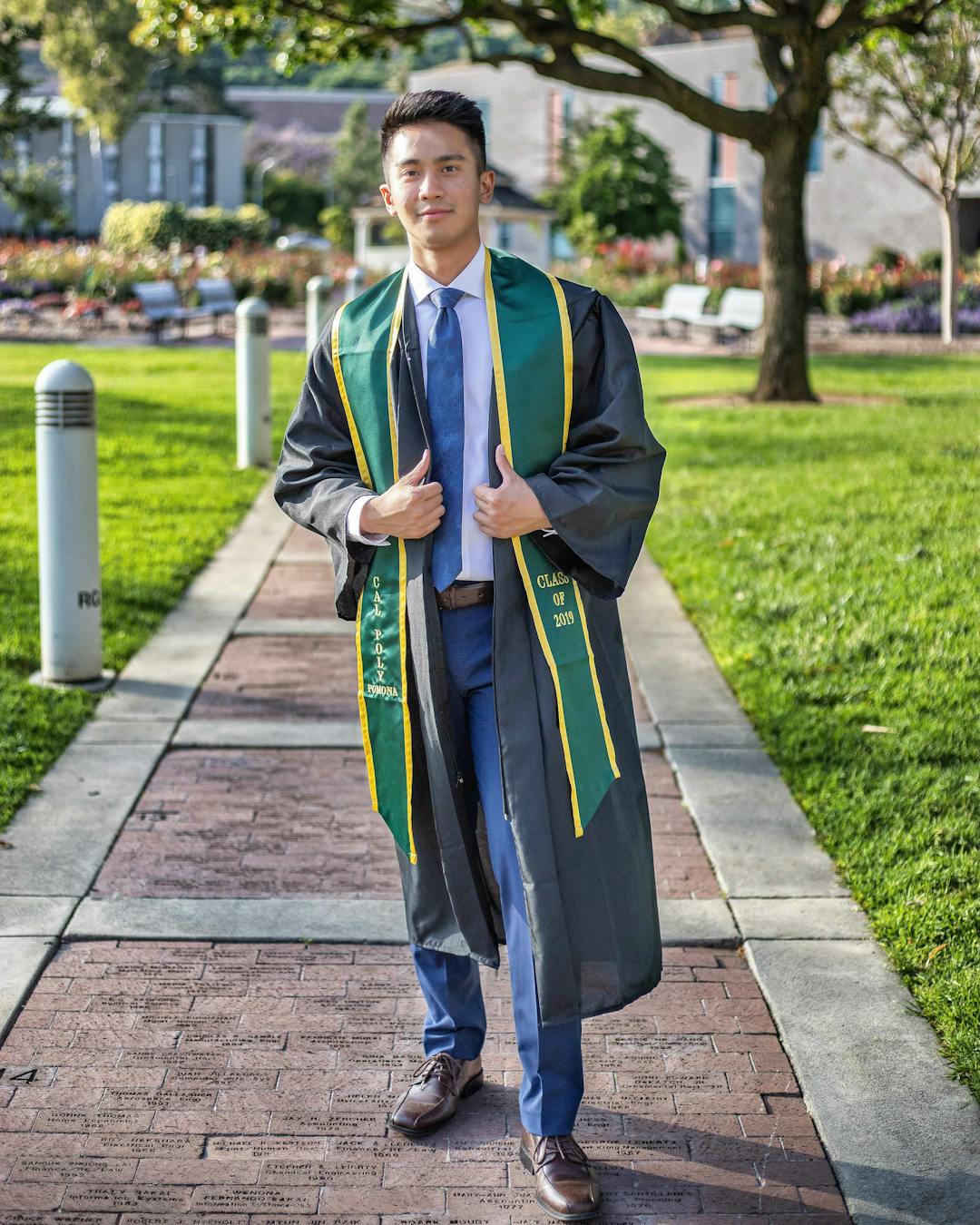 Man standing in graduation gown.