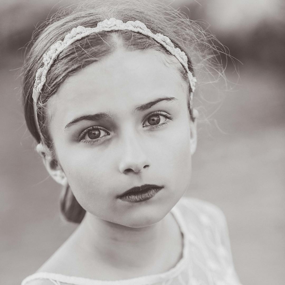 Little girl looking at camera in black and white.
