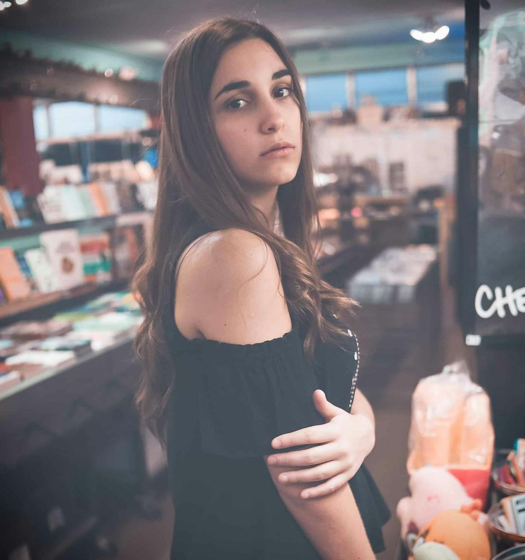Girl looking at camera in a bookstore.