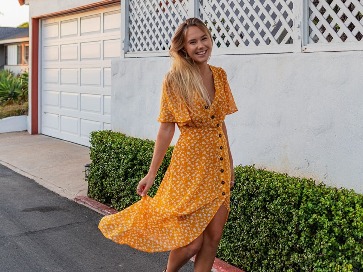 Candid portrait of a girl smiling in yellow sundress.