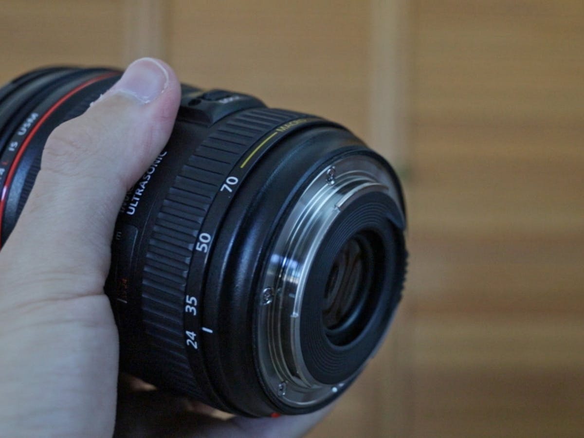 Canon EF 24-70mm f4L ISM meta lens mount in my hands.