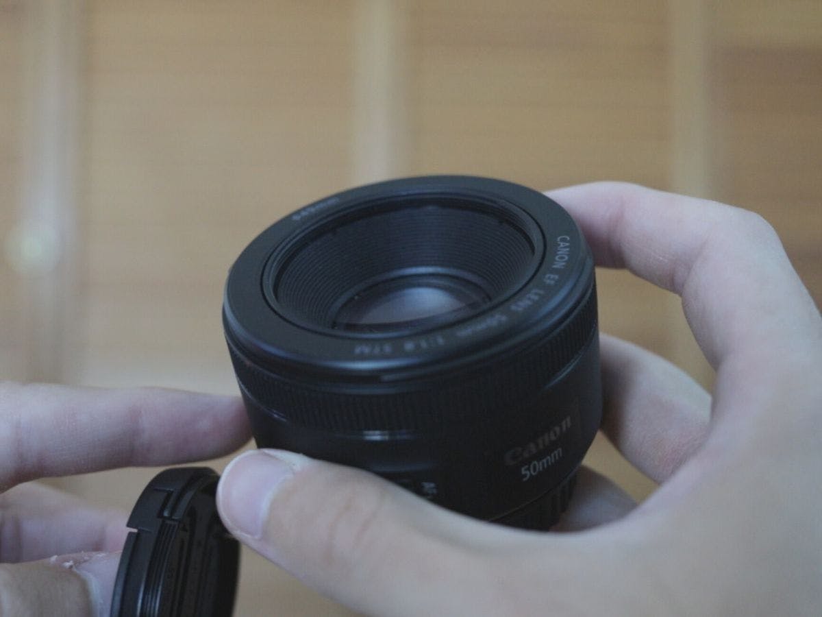 Holding the filter thread of the Canon EF 50mm f/1.8 in my hands.