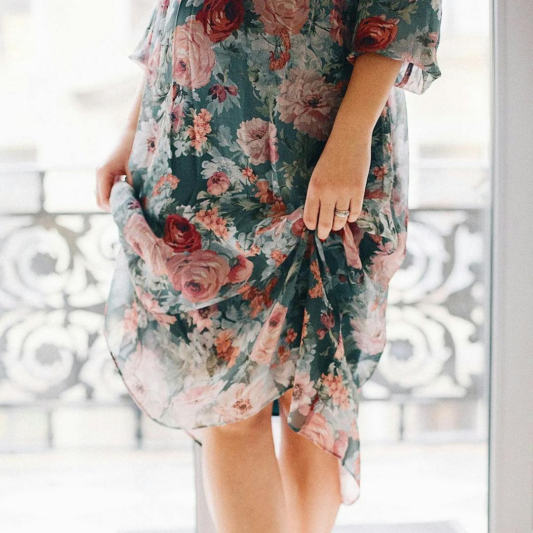Woman standing on toes with floral dress.