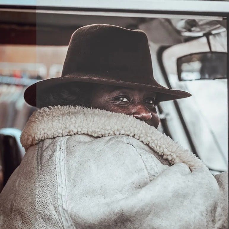 Man in car with fur coat.