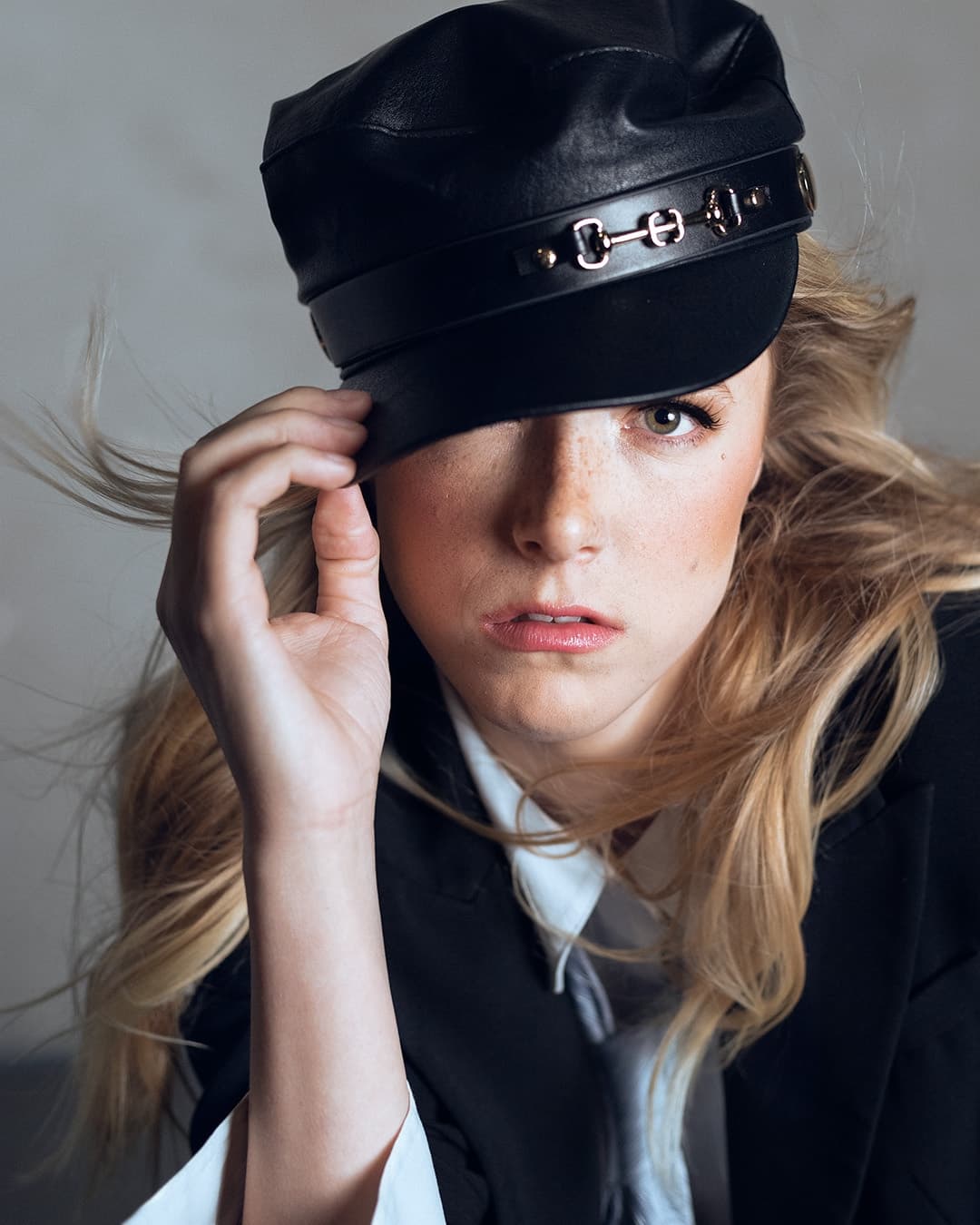 Example editorial portrait of a woman in hat and suit.