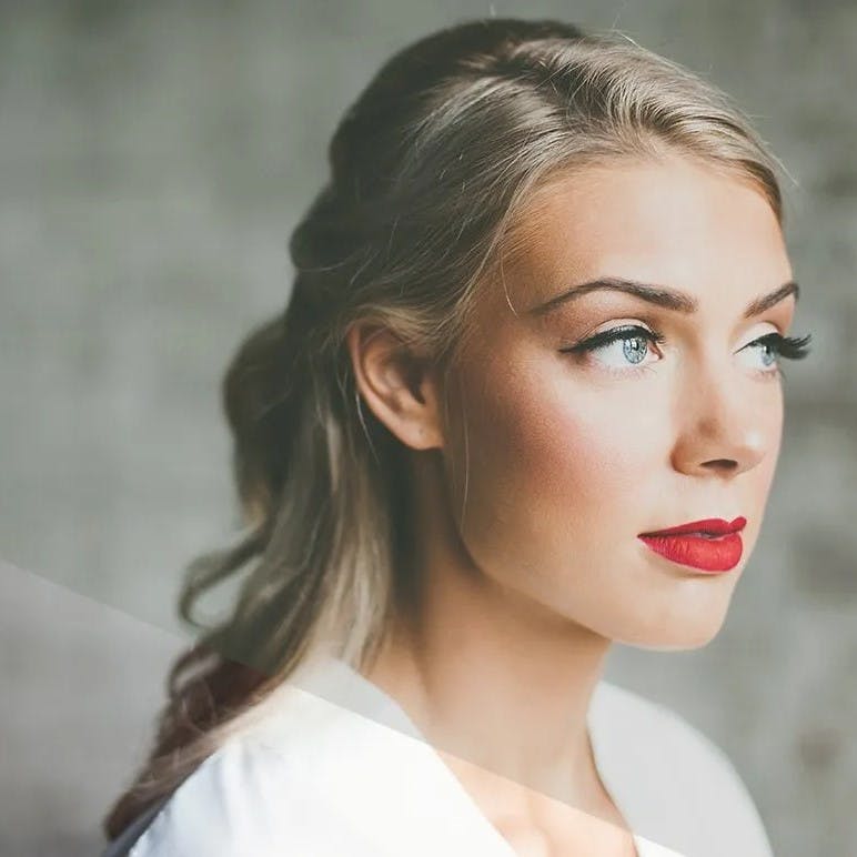 Woman with red lipstick looking outside.