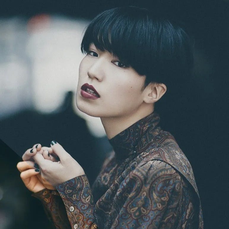 Woman with bowlcut and red lipstick.