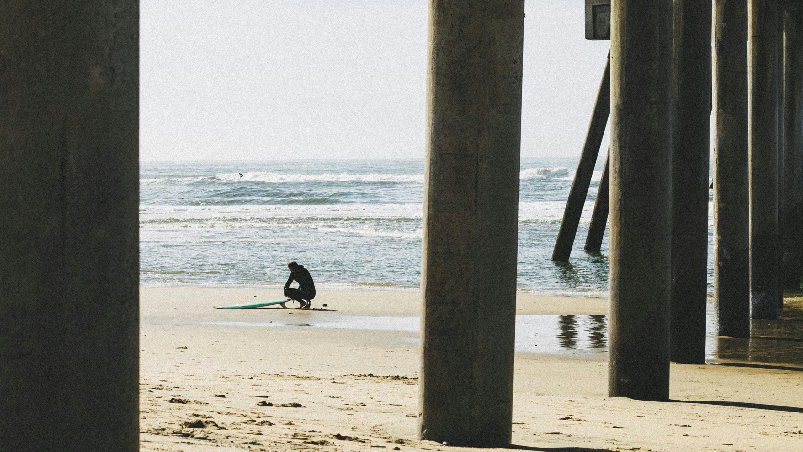 Surfer being framed between the pier columns.