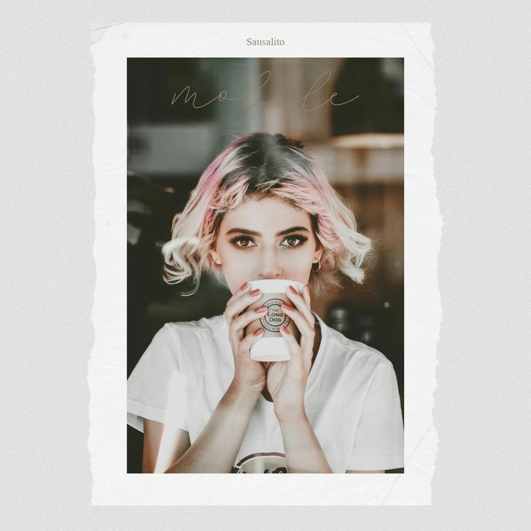 Girl with pink hair sipping coffee.