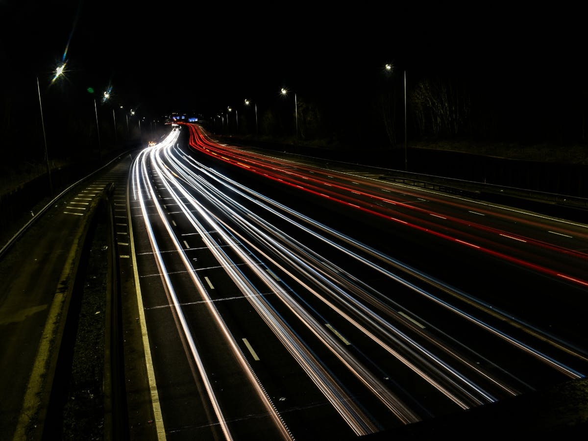 Car light streaks on a freeway due to long exposure time on camera.