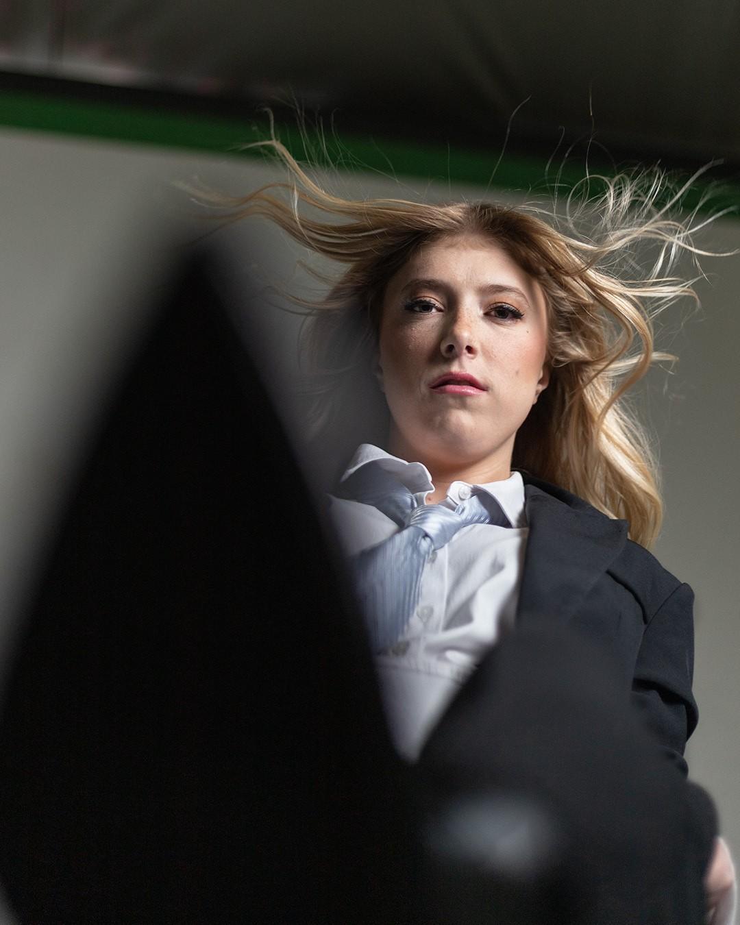 Woman extending shoe in front of camera from a low vantage point.