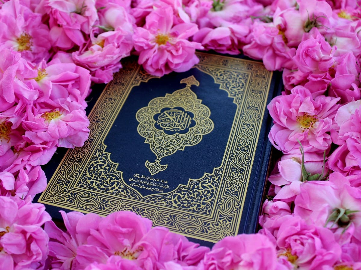 Islamic book in the middle of pink flowers.