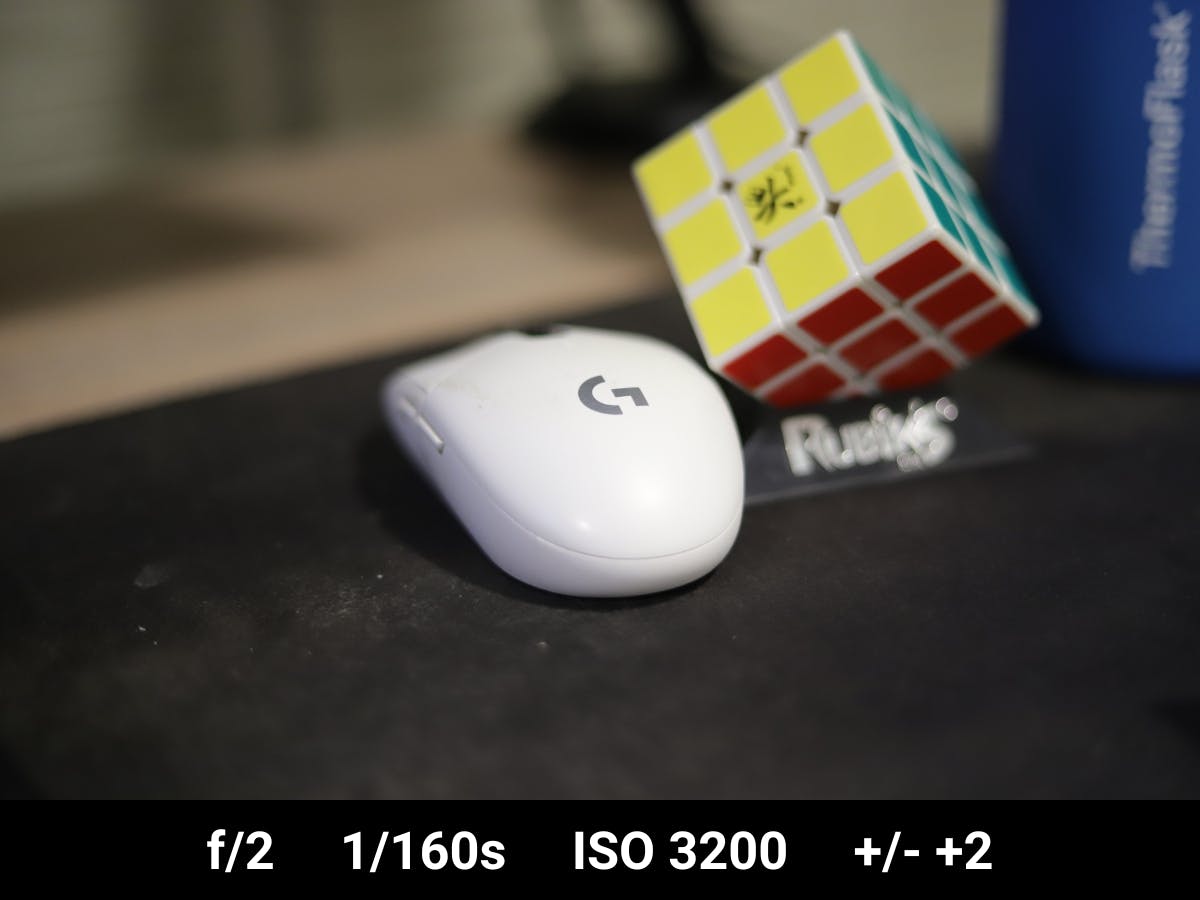 Mouse on a desk next to Rubik's cube in well-exposed photo.