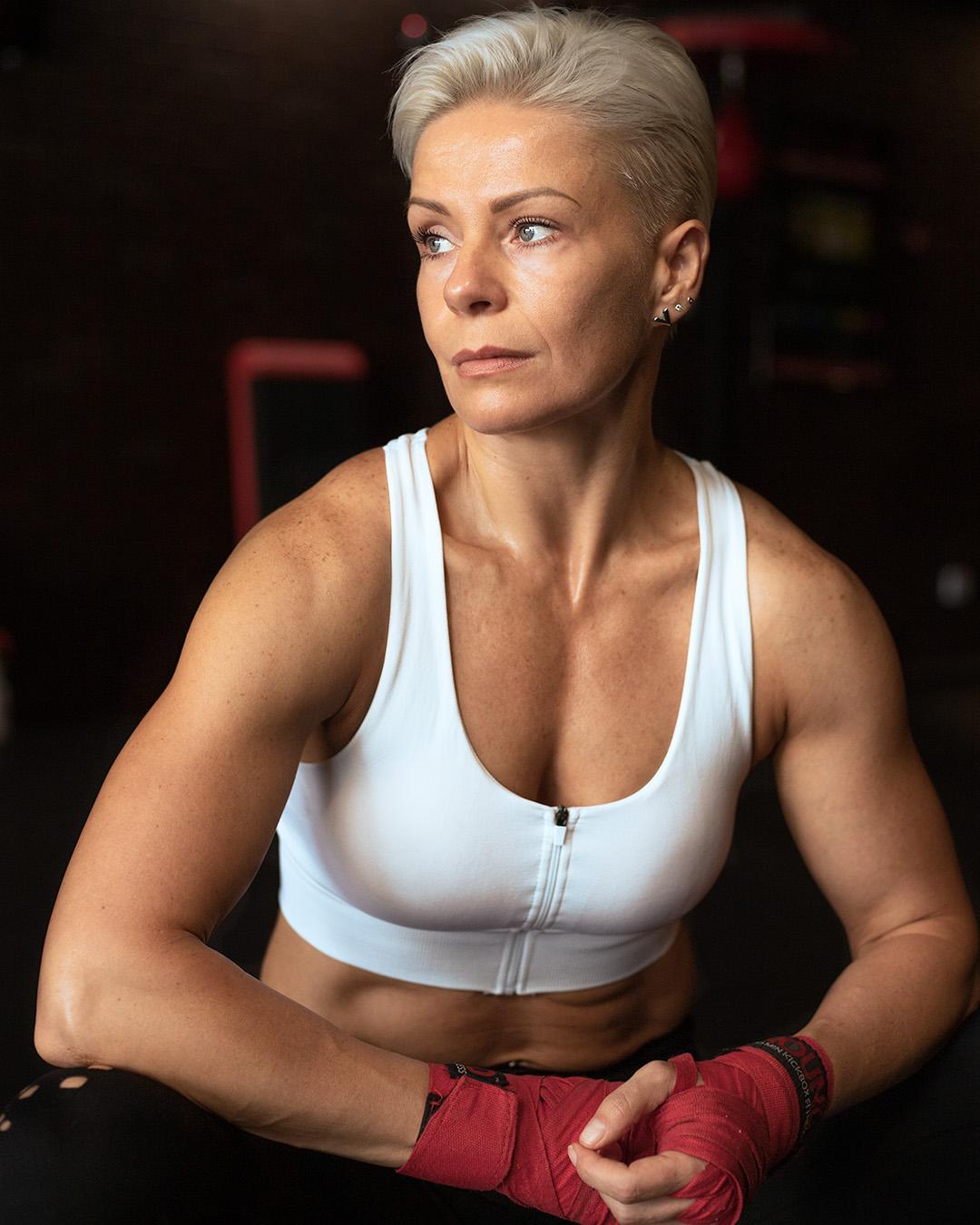 Woman sitting with knees on elbows facing inwards.