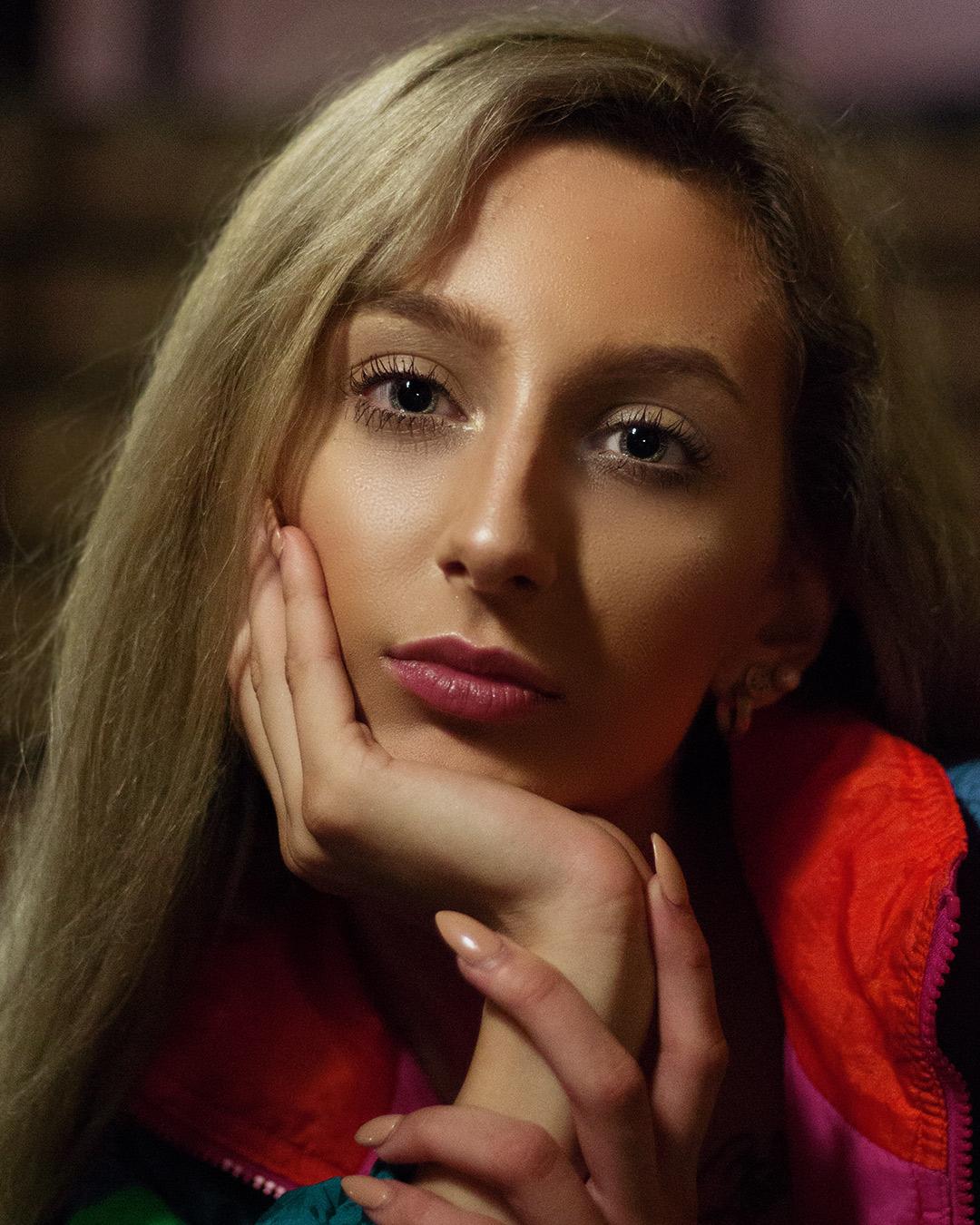 Woman sitting on the stairs with her hand cradling her chin.