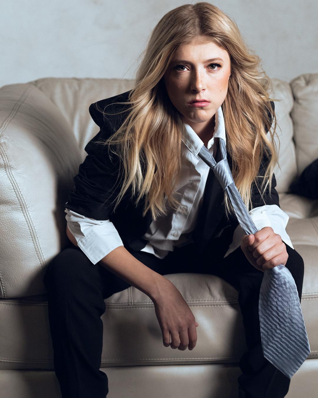 Woman sitting on a sofa sitting leaning to one side.