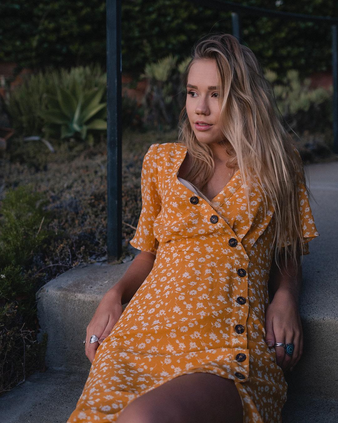 Woman sitting leaning back, arms on the sides.