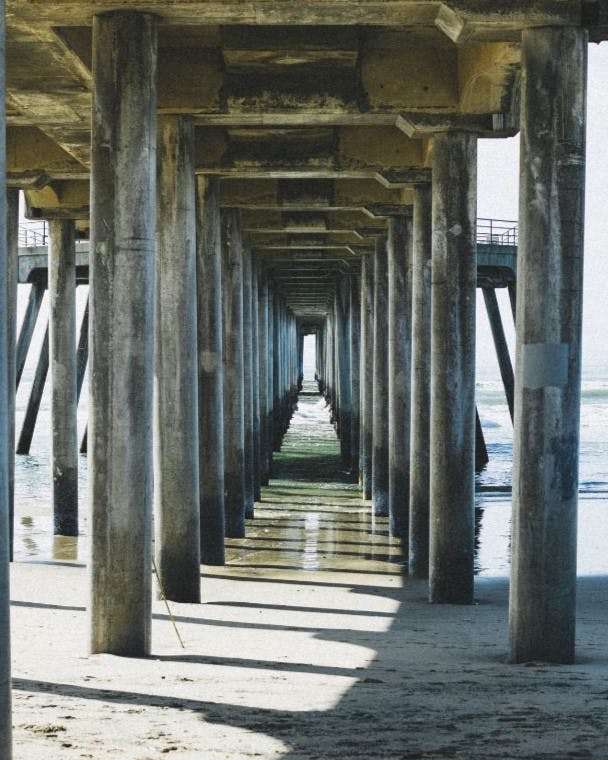 Underneath a pier with a row of columns for leading lines.