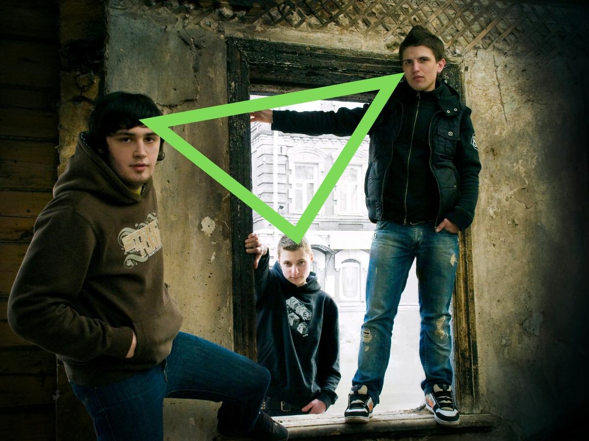 Group photo of three people in an abandoned building creating a triangle shape.