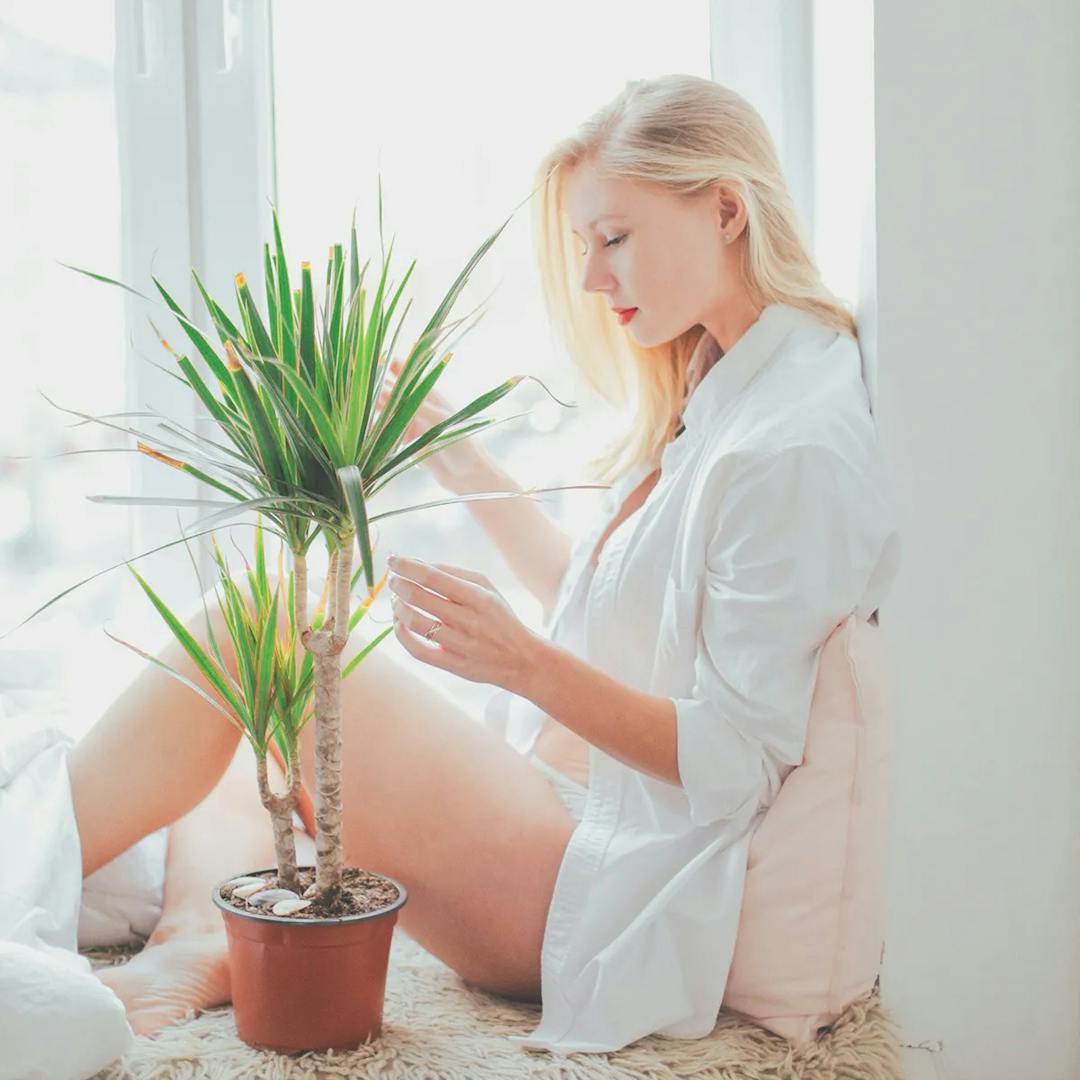 Woman with long sleeve shirt sitting on floor.