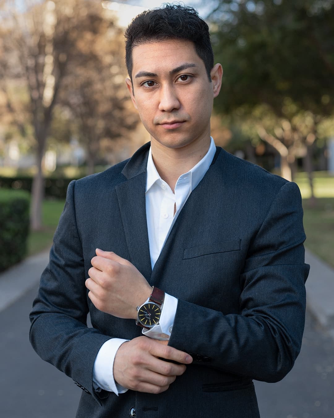Adjusting watch male pose Man posing in suit adjusting his watch.