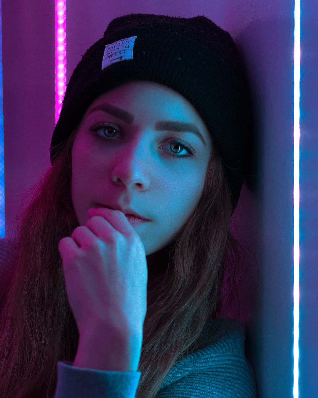 Portrait taken with the Canon EF 50mm f/1.8 Girl in front of purple and blue neon lights.
