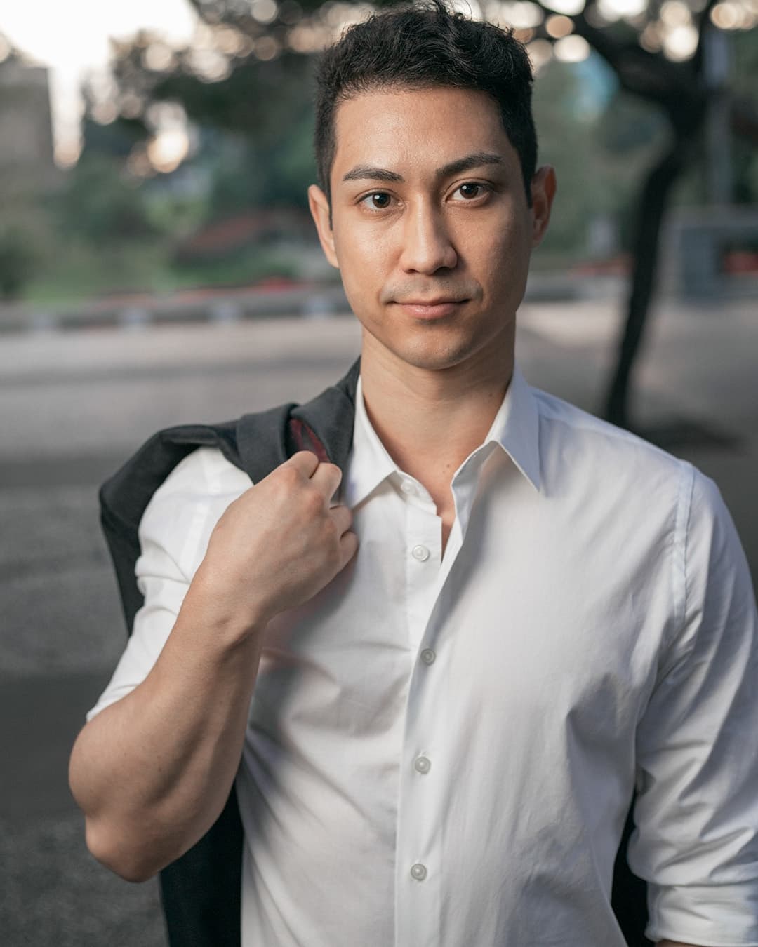 Jacket over the shoulder pose Man posing in white dress shirt with a jacket over the shoulder.