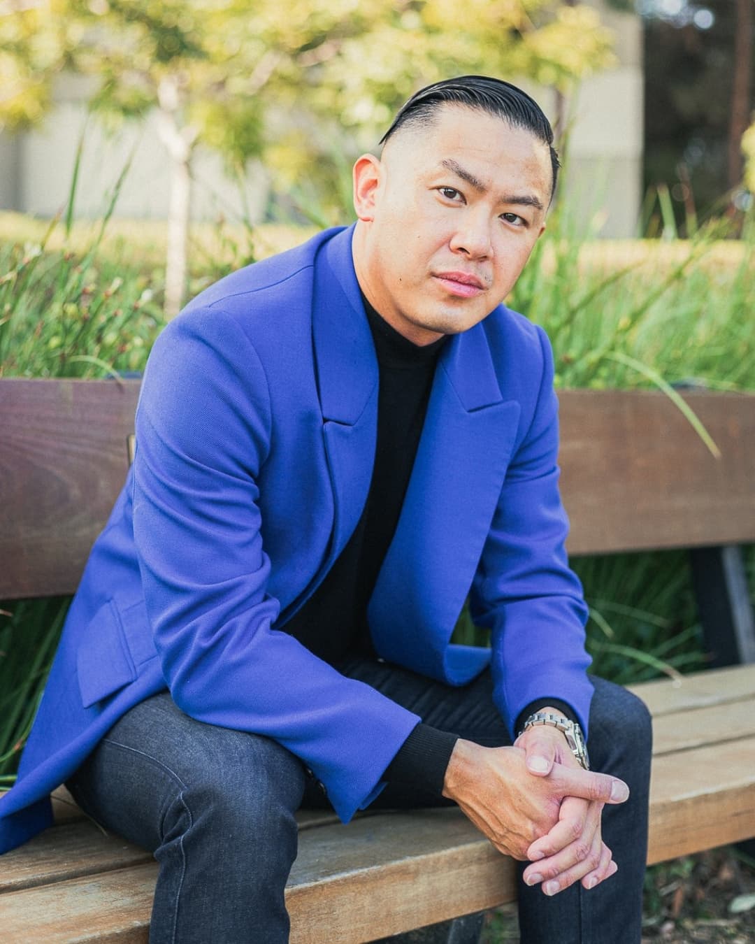 Leaning into arms male pose Man posing in blue suit sitting down leaning into his arms.