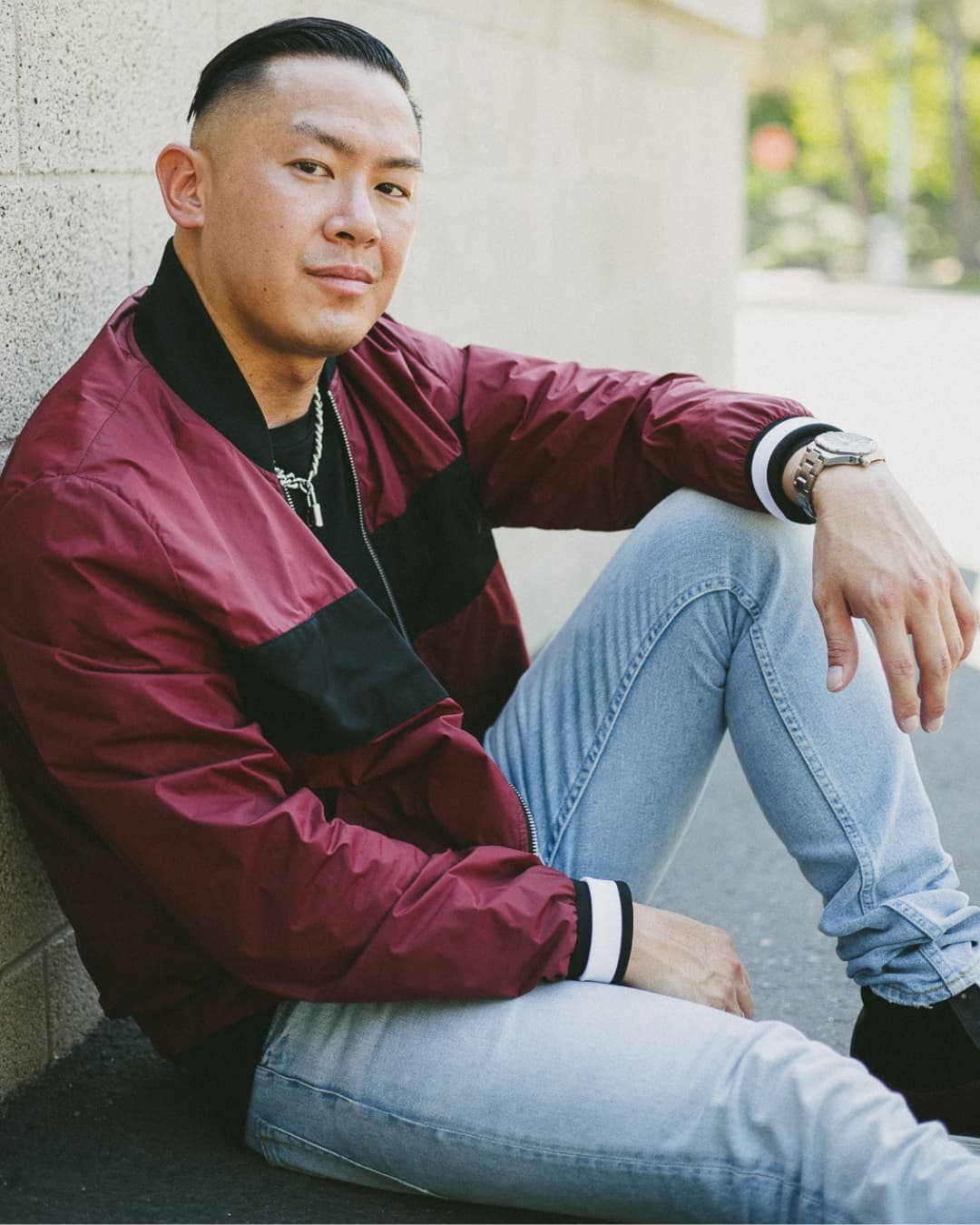 One knee up male pose Man posing in red jacket sitting down with one knee up.