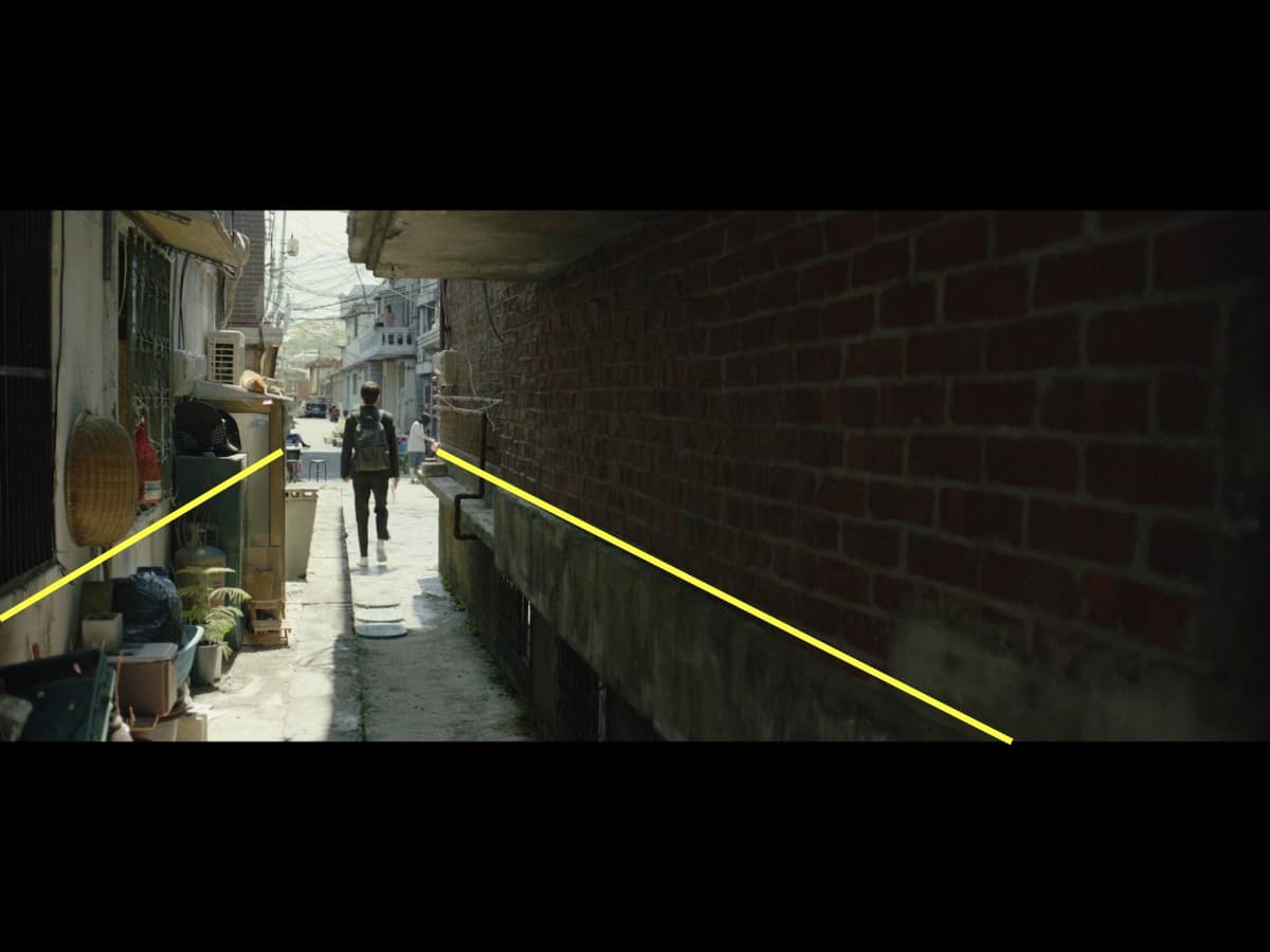 Parasite scene 5 - first frame leading lines Leading lines composition from Ki-Woo leaving house scene in Parasite.