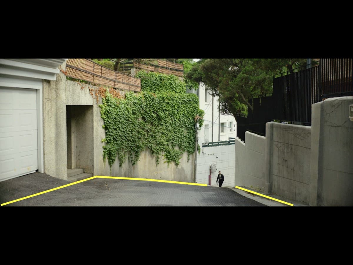 Parasite scene 5 - second frame leading lines Leading lines composition from Ki-Woo walking up alley scene in Parasite.