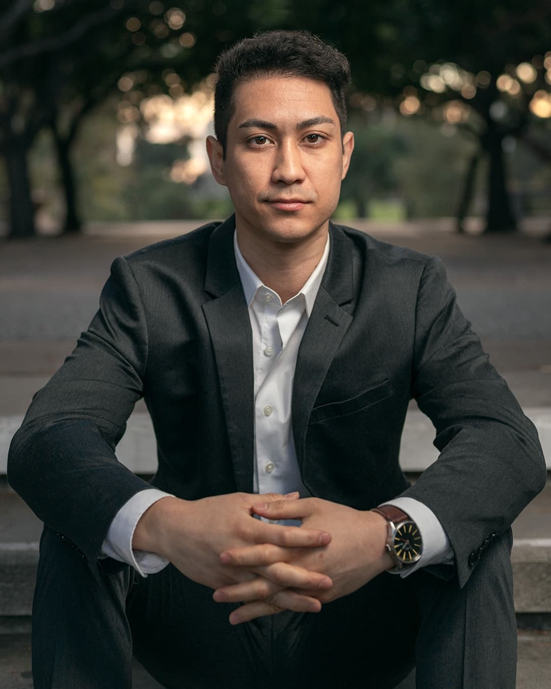 Sitting hands grasped male pose Man posing in suit sitting hands grasped.
